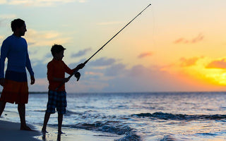 father and son fishing on beach