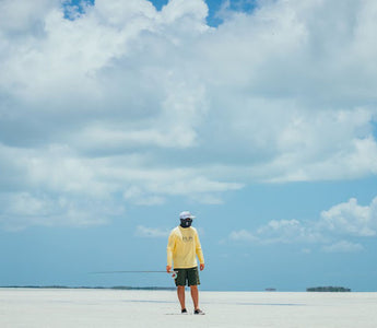 walking on a beach with a fishing pole