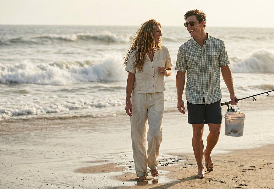 Man and woman walking on a beach with fishing gear