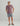 Mauve short-sleeve t-shirt with chest pocket and white graphic print, worn with gray shorts.