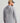 Gray Huk hoodie tee with back graphic print, worn with tan and black baseball cap.