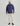 Man wearing navy fleece shacket with chest pockets, cream beanie, cream pants, and dark boots.