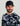 Man wearing black and white camouflage print hoodie with white collar and black mesh baseball cap with embroidered logo.