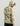 Man wearing cream and green camo print lightweight fleece hoodie with attached hood and black cap, shown from back view.