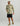 Man wearing cream and green camo fleece hoodie with black shorts and tan cap.