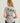 Gray women's v-neck tee with palm tree graphic on back and small text detail.