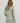 Sage green long-sleeve cover-up dress with cowl neckline and side drawstring details, shown from back view.