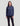 Navy blue women's quarter-zip pullover with long sleeves worn with black pants.