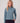 Woman wearing a slate blue heathered fleece half-zip pullover with long sleeves and black pants.