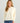 Woman wearing HUK Women's Leeward Boxy Fleece Hoodie in Egret