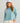 Woman wearing HUK Women's Leeward Boxy Fleece Hoodie in Reefline Heather