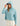 Woman wearing HUK Women's Leeward Boxy Fleece Hoodie in Reefline Heather