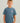 Child wearing a slate blue short-sleeve t-shirt with "HCK" graphic embroidered on chest.