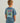 Child wearing slate blue t-shirt with colorful graphic print on back featuring text and action imagery.
