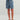 Kid wearing blue shorts with shark pattern on a plain background