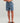 Kid wearing blue shorts with shark pattern on a plain background